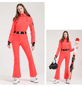 Detail of red one-piece ski suit with slim fit design and black elastic waist belt