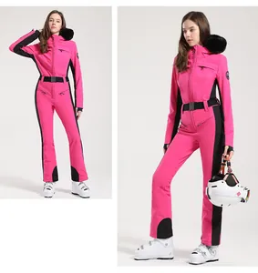 Détail d'une combinaison de ski rose une pièce avec panneaux noirs et col en fausse fourrure