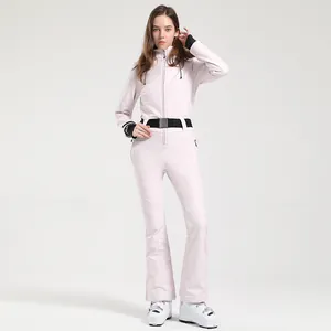 Slim fit women's one-piece ski suit in light pink with black waist belt and hood