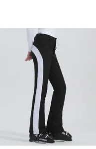 Vista laterale dei pantaloni da sci neri da donna con strisce bianche, tessuto elastico invernale