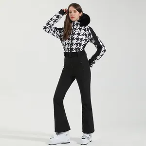 Women's one-piece ski suit with houndstooth pattern, faux fur collar and black belt