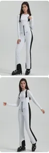 Detail of waterproof white ski bib pants with black side stripes and adjustable straps