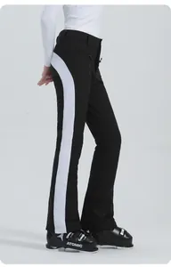 Dettaglio dei pantaloni da sci neri con strisce laterali bianche e fondo svasato donna