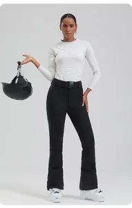 Detailed look of black high-waisted ski pants with adjustable belt and white ski boots