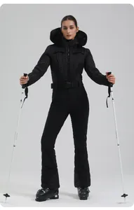 Close-up of women's black quilted ski jacket with faux fur hood and belted waist