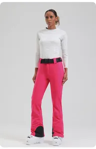 Detail view of pink slim-fit ski pants with adjustable black waist belt and snow gaiters