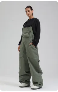 Details von militärgrüner wasserdichter Skilatzhose mit schwarzen Trägern und Taschen