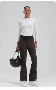 Women's slim fit ski pants and white thermal top with professional black helmet and boots