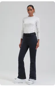 Detail of slim-fit high-waisted ski pants with a decorative branded belt and white ski boots