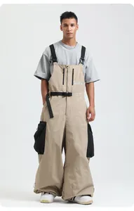 Dettaglio dei pantaloni da sci kaki con bretelle e ampie tasche cargo laterali resistenti