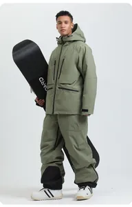 Front full-body view of a model in green waterproof ski jacket and pants with a snowboard