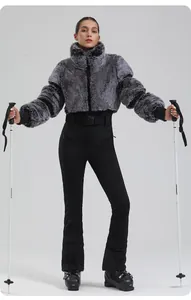 Detailed view of women's ski set with grey faux fur jacket and slim fit black trousers