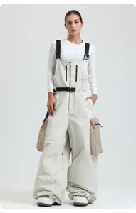 Dettaglio dei pantaloni da sci beige con spalline regolabili e tasche cargo laterali