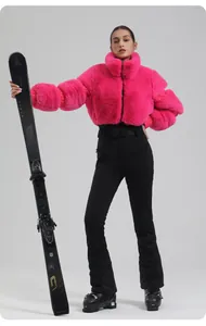 Detail of pink faux fur ski jacket and slim fit black trousers for winter sports
