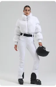 Full body view of women's white slim-fit ski suit with faux fur collar and black belt