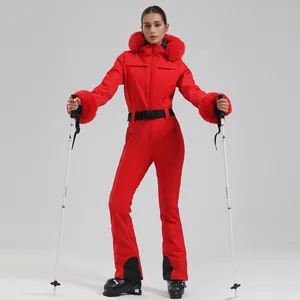 Women's red one-piece ski suit with fur hood and black belt on white background