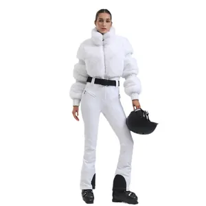 Women's slim fit winter ski suit with white faux fur jacket and black belted trousers