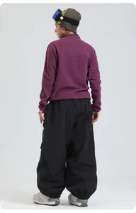 Rear view of purple fleece jacket and black wide-leg waterproof snow pants for skiing