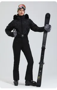 Details einer schwarzen gesteppten Damen-Skijacke mit Pelzkragen und schmaler Skihose