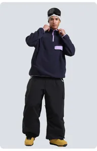 Winter ski outfit featuring dark blue fleece pullover and black cargo snow pants