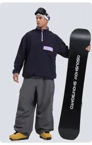 Detail of loose multi-pocket ski pants with dark blue fleece and yellow ski boots