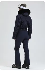Rückansicht des dunkelblauen Damen-Skianzugs mit gesteppter Jacke und schwarzem Pelzbesatz