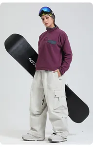 Détail du sweat à capuche en polaire violet et du pantalon de ski large crème pour les sports