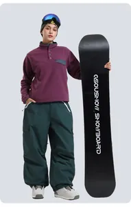 Detail of purple fleece pullover and dark green multi-pocket cargo ski pants on model
