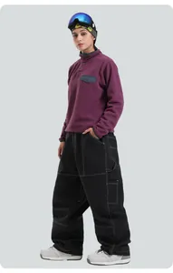 Close-up of black wide-leg ski pants with white contrast stitching and durable waterproof fabric