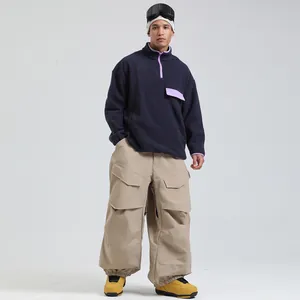 Mens winter ski outfit with navy fleece pullover and khaki wide-leg cargo snow pants