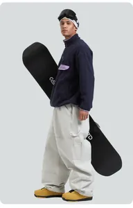 Deep blue fleece jacket and beige wide-leg snow pants with a snowboard gear setup