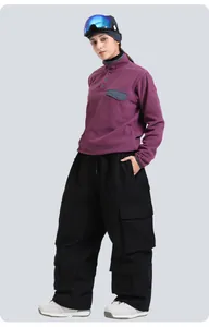 Purple fleece half-zip top with black cargo ski pants and blue mirrored goggles