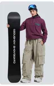 Close-up of khaki multi-pocket waterproof cargo ski pants and GSOUSNOW snowboard equipment