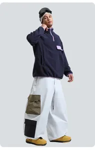 Detalle de pantalones de esquí cargo blancos con grandes bolsillos utilitarios verde oliva