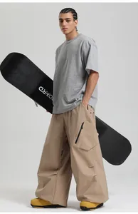Detailed view of khaki wide-leg cargo pants with zip pockets and yellow outdoor boots