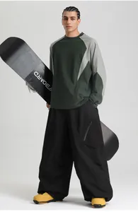 Detail of oversized black cargo ski pants with side zipper pocket and baggy fit