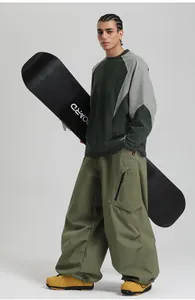 Detail of loose-fit windproof cargo ski pants and bicolor long-sleeve hiking sweatshirt
