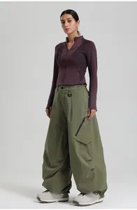 Detail of olive green cargo ski pants featuring large zipper pockets and D-ring buckle