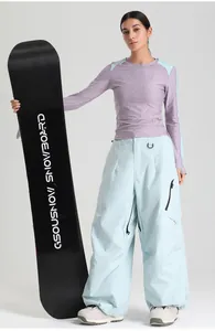 Close-up of mint green wide-leg ski pants featuring side zipper pockets and high waist