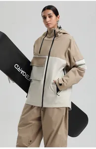 Détail de la tenue de ski imperméable kaki et crème avec multi-poches et veste à capuche