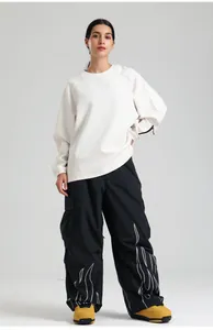 Detail of black cargo pants featuring white flame pattern and large side pockets