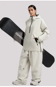 Detalle de chaqueta de esquí impermeable blanco roto con gran bolsillo frontal y velcro