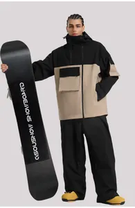 Vue détaillée de la veste de ski à capuche bicolore et du pantalon noir à poches multiples