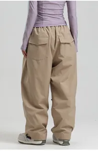 Detail view of khaki wide-leg ski pants with elastic waist and back cargo pockets