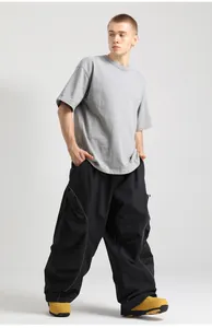 Detail view of black loose-fit cargo ski pants featuring white contrast side-stripe stitching