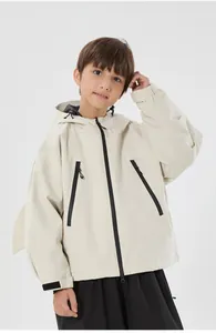Detail of kids beige hooded ski jacket showing black zipper pockets and velcro cuff straps