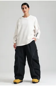 Detail of loose black cargo snow pants with reflective strips and utility side pockets