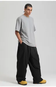 Full body shot of loose waterproof ski pants and short sleeve top on a studio model