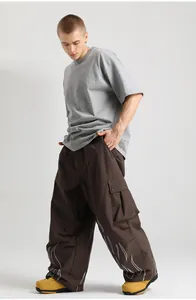 Detail of loose wide-leg ski pants with reflective flame print and functional cargo pockets