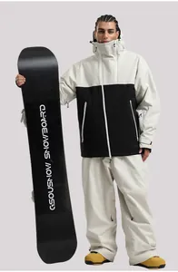 Détail d'une veste de ski à capuche contrastée et d'un pantalon avec zips étanches